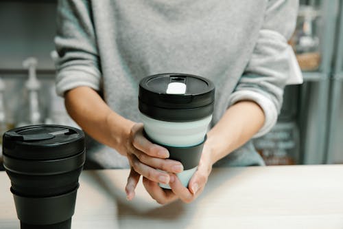 Person Holding Black and White Silicon Collapsible Cup
