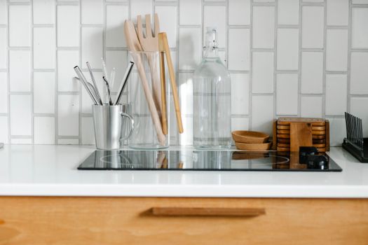Glass water bottle and kitchenware on a clean kitchen counter