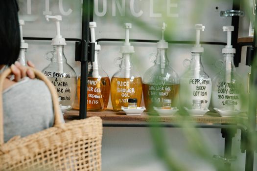 Display of eco-friendly personal care products in refillable bottles on a shelf, promoting sustainability.