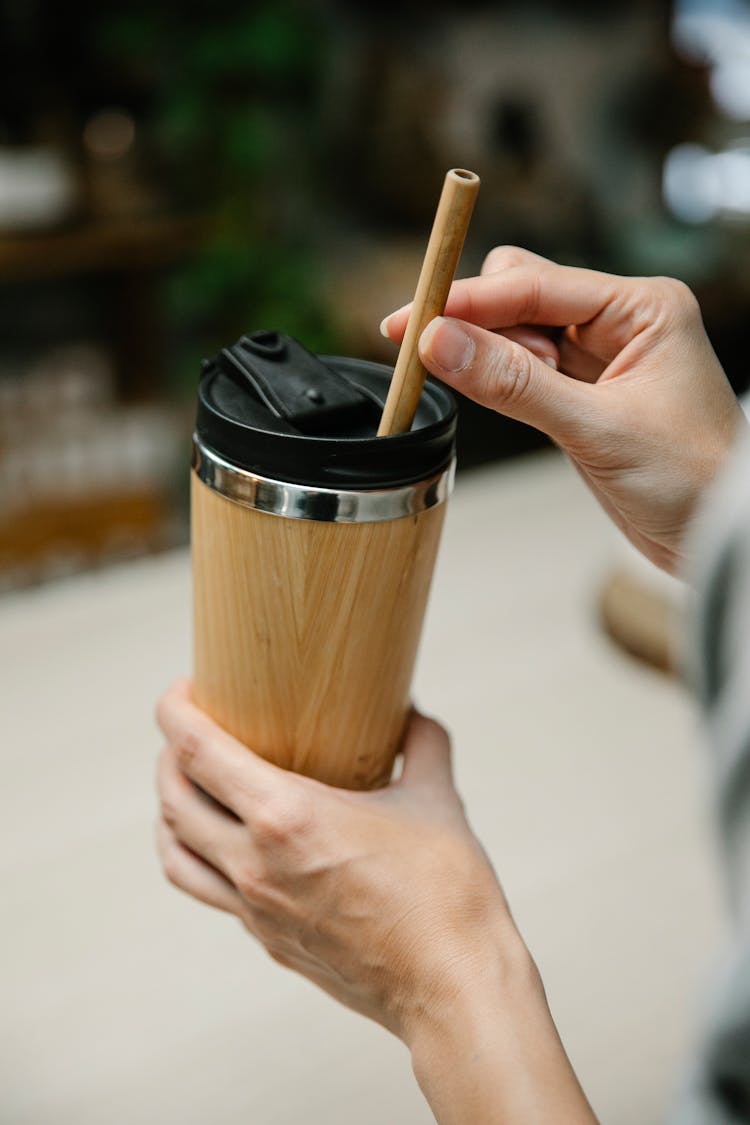 A Person Holding A Tumbler And A Biodegradable Straw