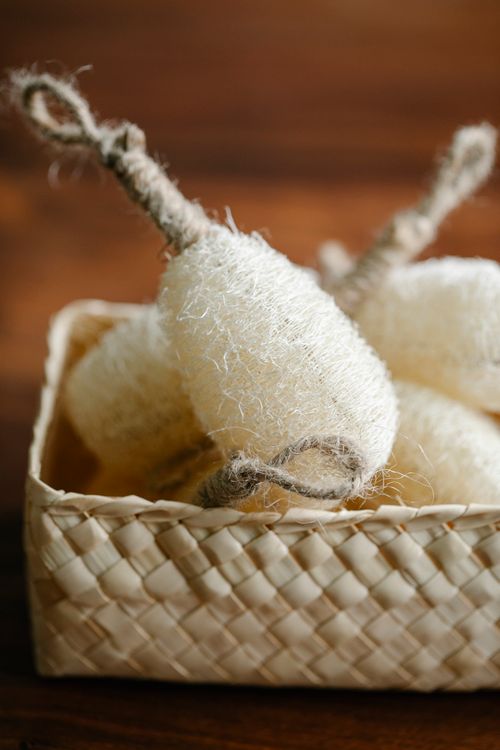 Free Heap of white ECO friendly shower sponges for body care routine placed on wooden table in light room at home Stock Photo