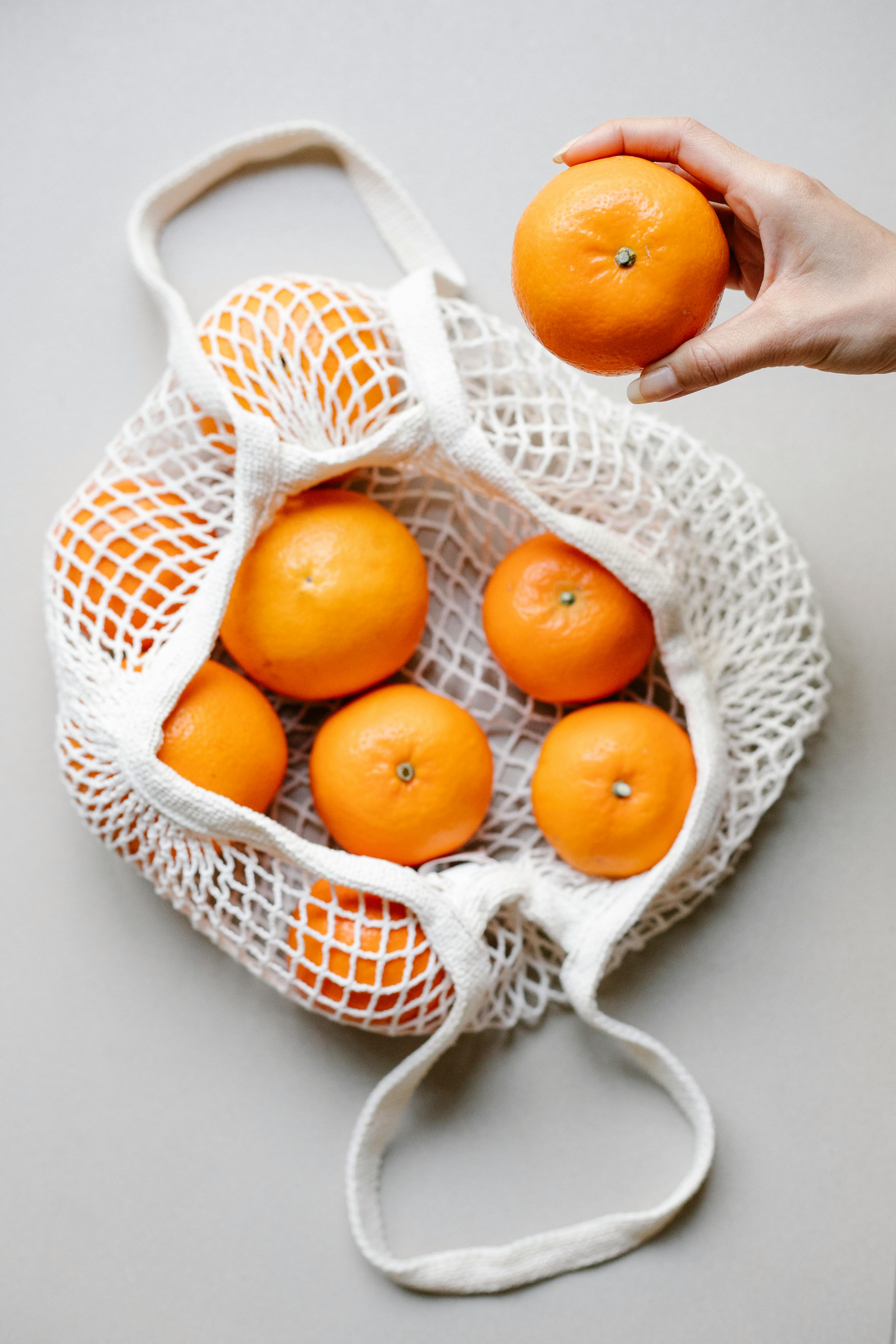 Fresh citrus fruits tangerines, oranges close-up on cotton mesh bag, rustic  style Stock Photo - Alamy