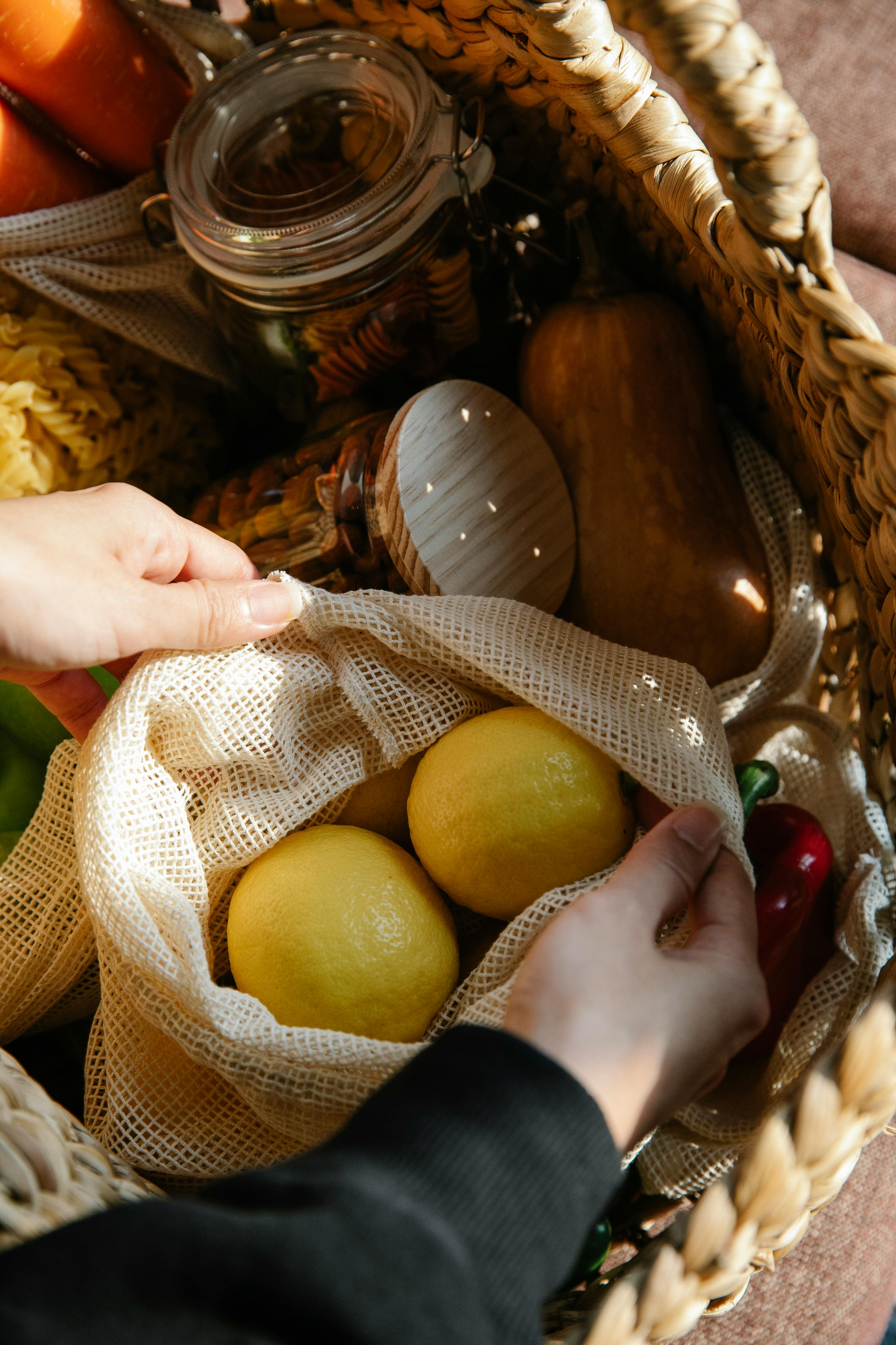 unrecognizable shopper with lemons in wicker basket