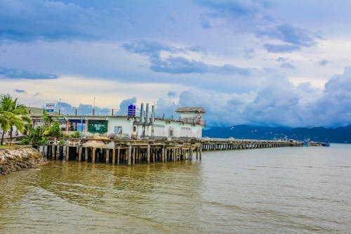 White Concrete Building Beside Body of Water Under Blue and White Sky at Daytime