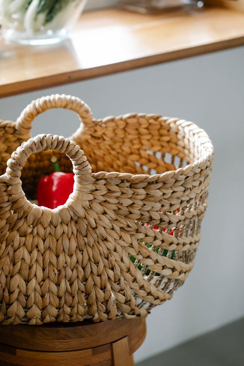 Wicker basket with vegetables on stool in kitchen