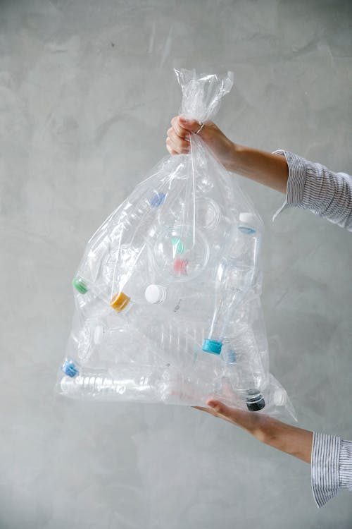 Anonymous person with bag of plastic bottles