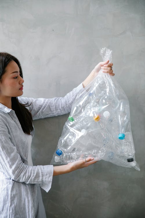 Asian woman with bag of plastic bottles