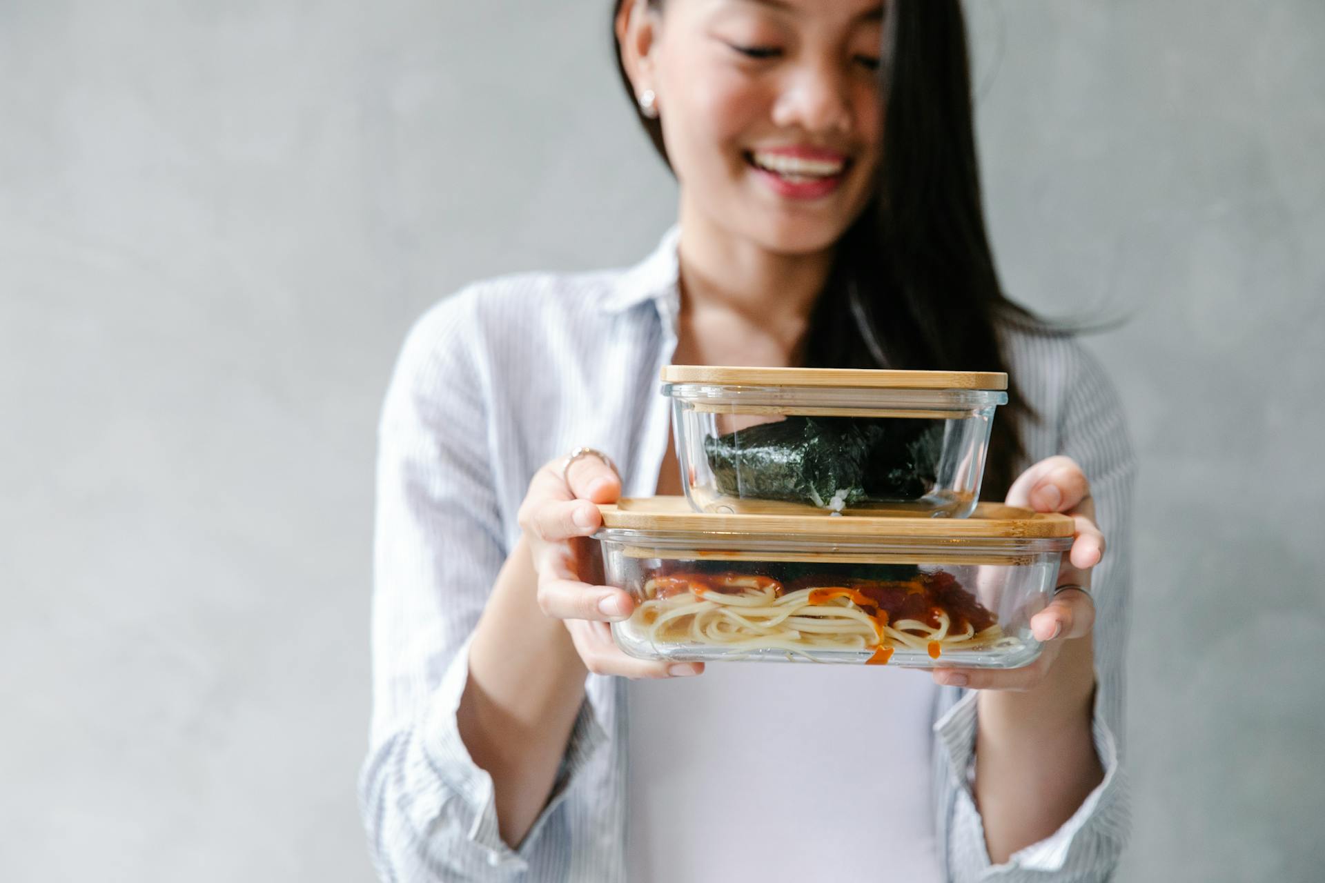 Cheerful Asian woman with food in containers