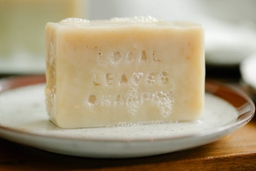 Close-up of a natural handmade soap bar with bubbles on a ceramic plate indoors.