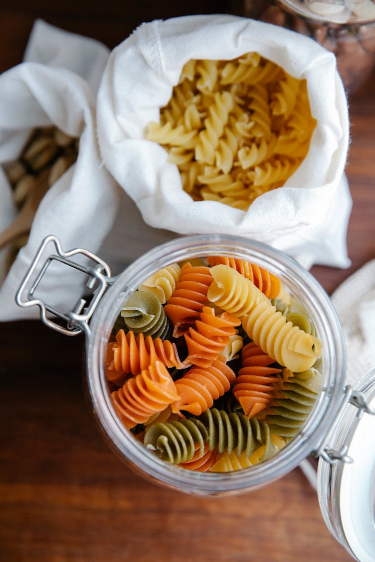 Uncooked Fusilli Placed In Sack And In Jar On Table