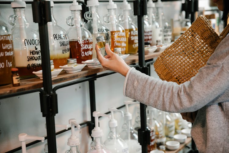 Crop Customer Examining Glass Jar With Shampoo