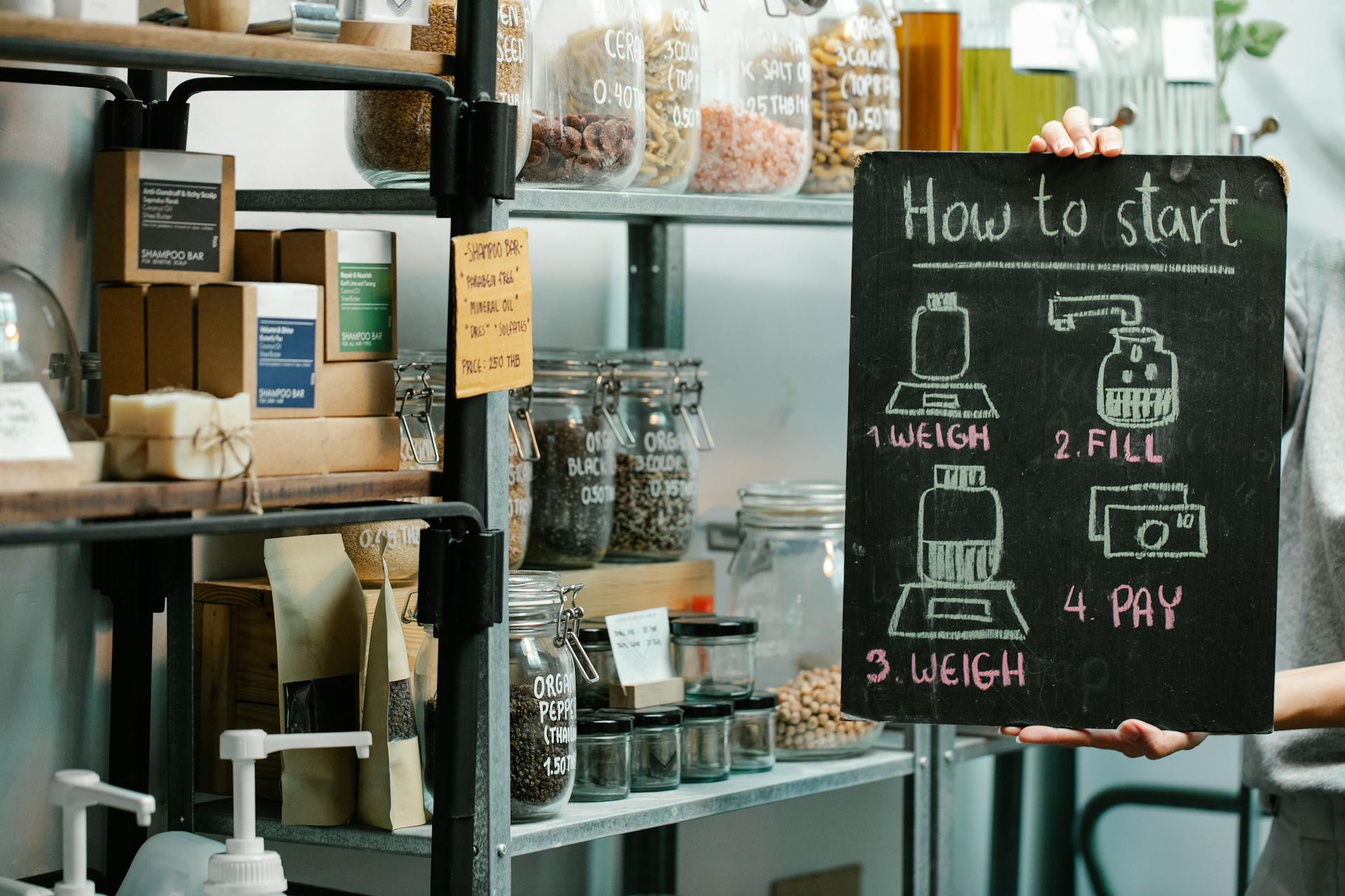 Assorted natural products and food in glass jars and paper packages on shelves in self service eco shop