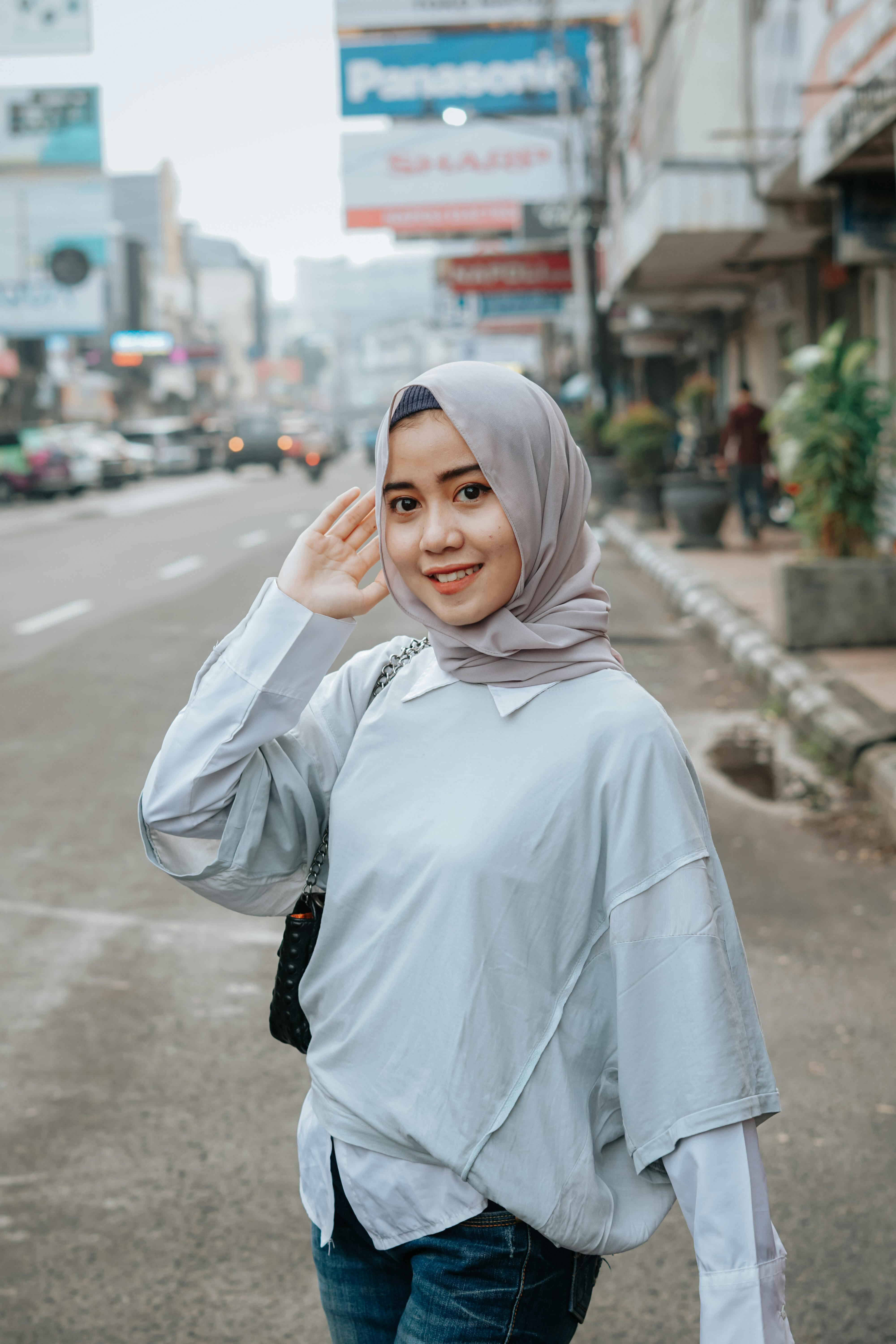 Positive Asian Muslim woman in gray hijab · Free Stock Photo