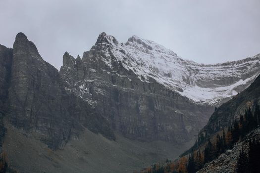 A stunning view of a rocky mountain peak covered in snow, capturing nature's grandeur.