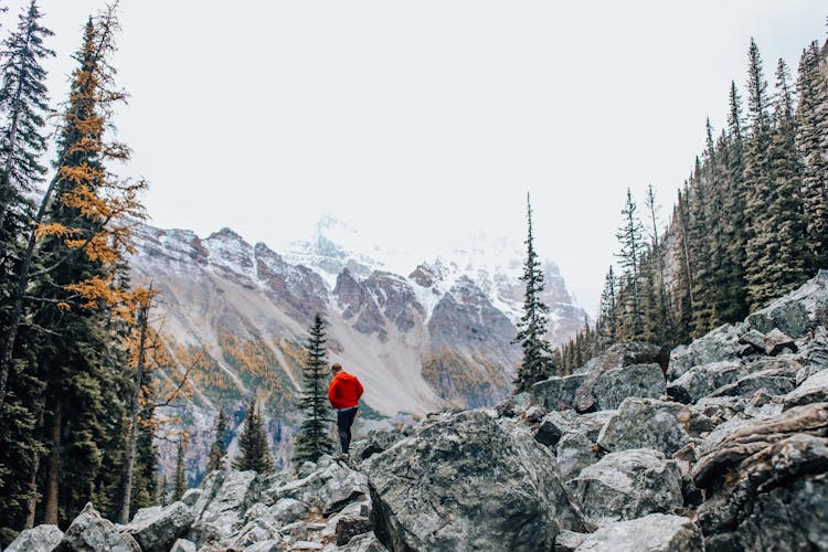 Man Walking On Rocky Mountainside