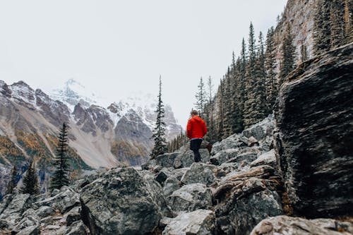 Man Wearing Red Jacket Walking on Mountainside