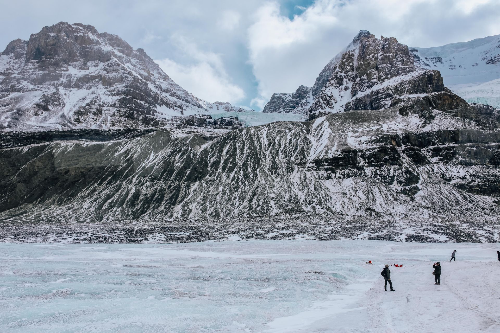 A breathtaking view of Athabasca Glacier surrounded by snow-covered mountains and icefields.