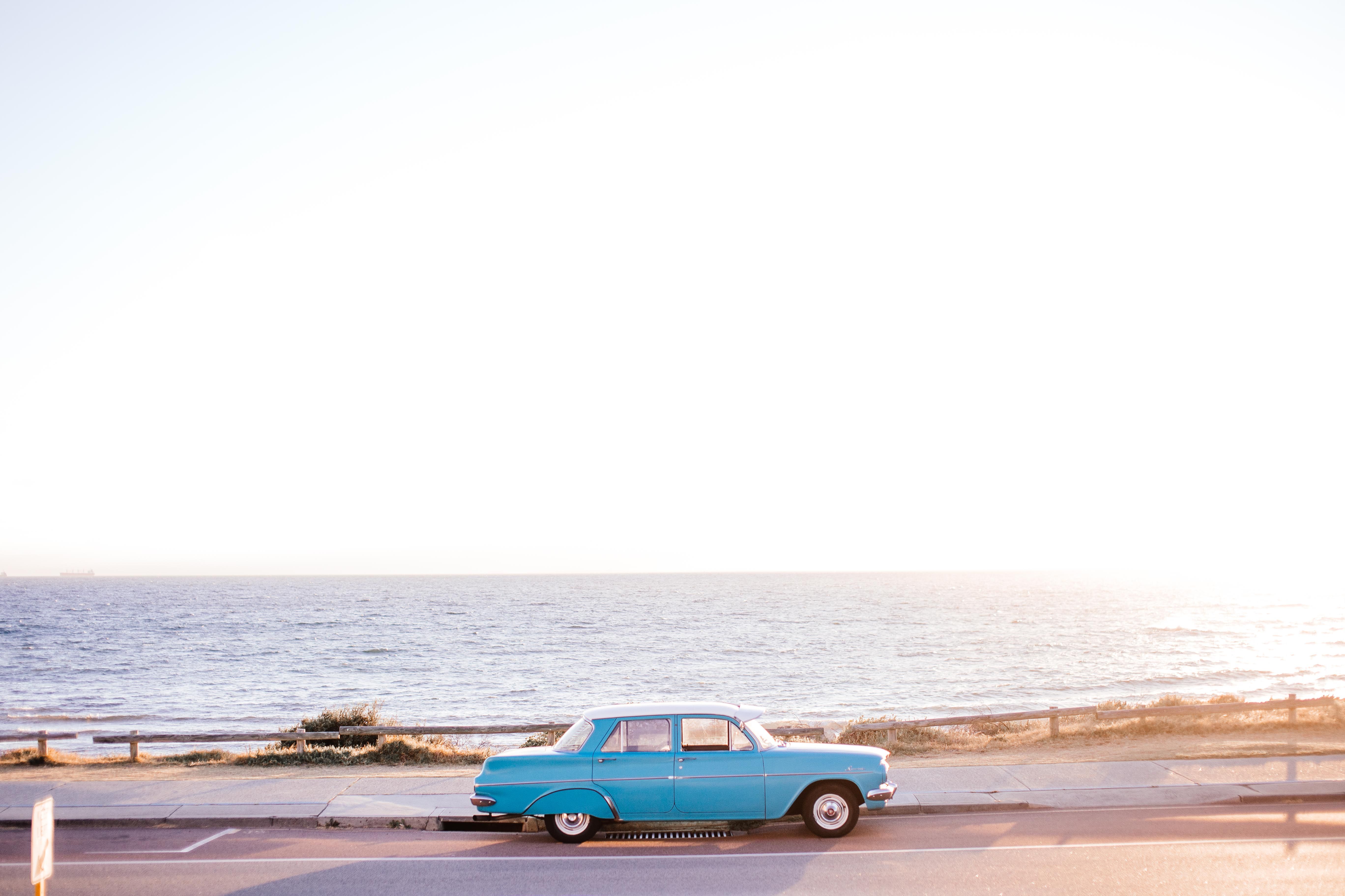 A Car Parked on the Road by the Sea · Free Stock Photo