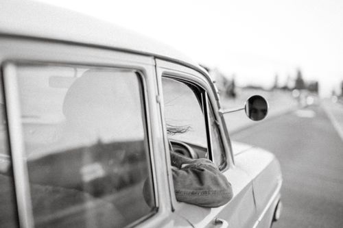 Free Vintage car journey with a person enjoying the view, creating a nostalgic vibe. Stock Photo
