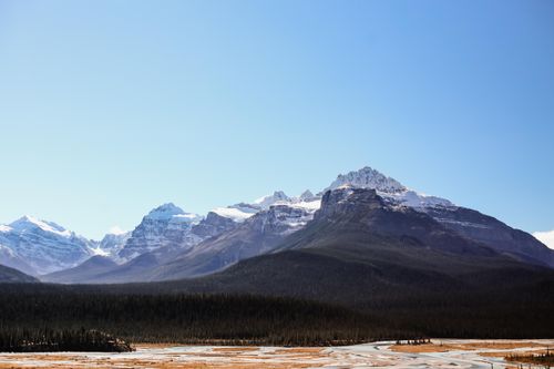 Free Stunning view of a snow-capped mountain range under a clear blue sky, ideal for nature and travel themes. Stock Photo