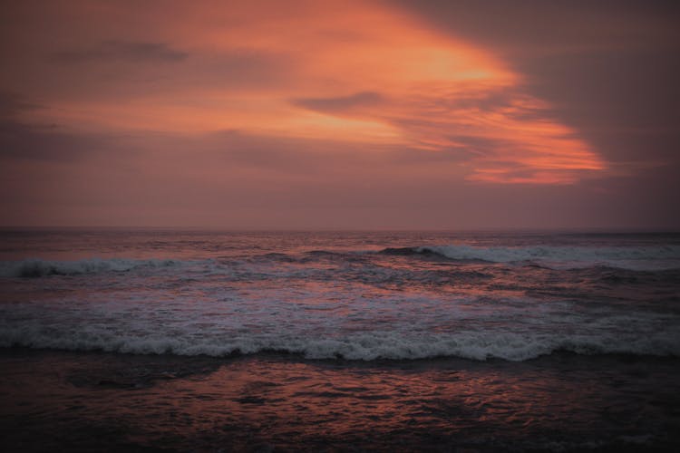 Waves Crashing On The Shore During Sunset