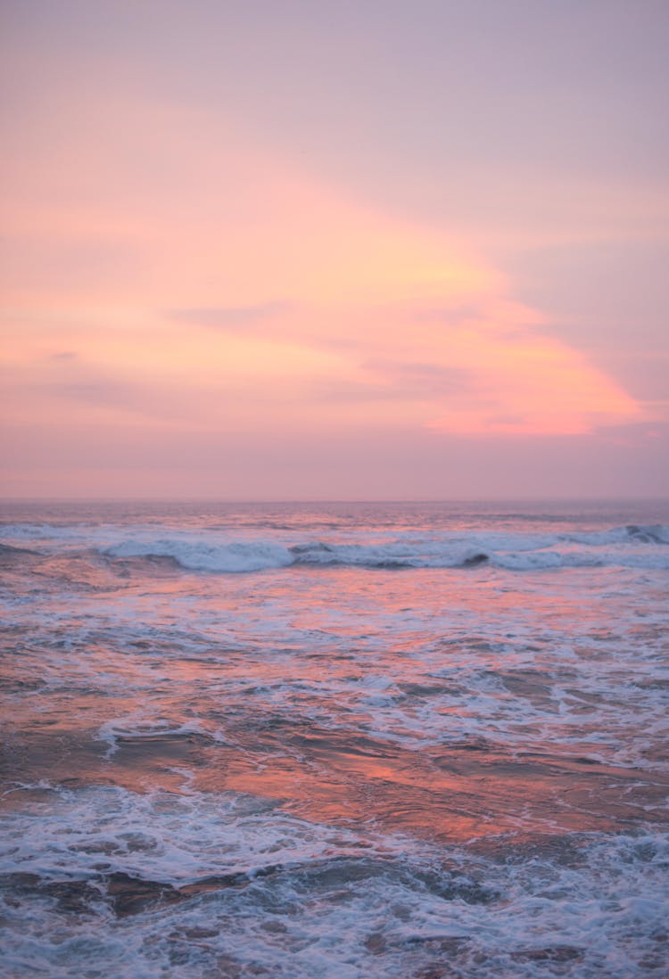 Waves Crashing On The Shore During Sunset