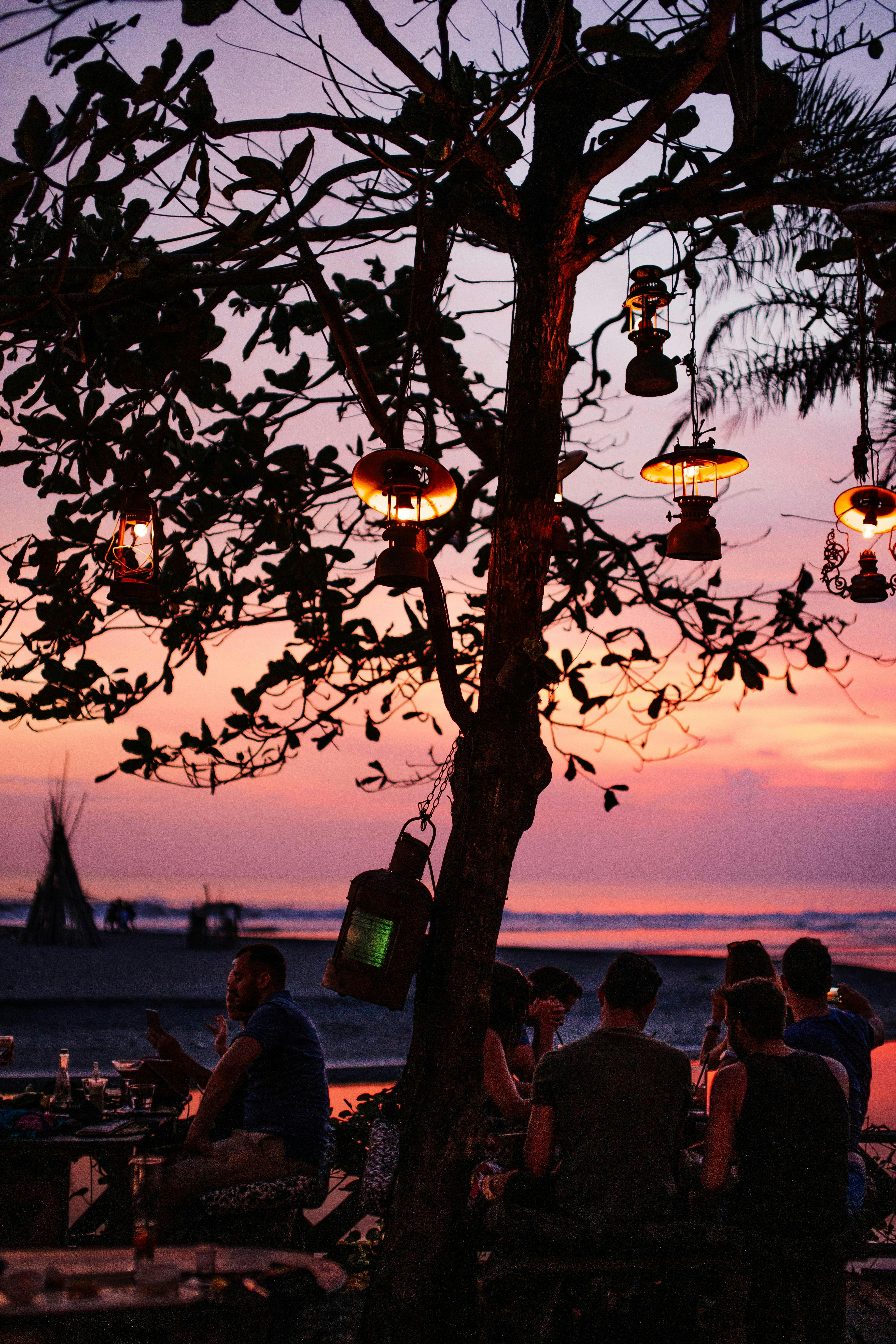 Sunset crowd with cocktails at a beachfront bar on Batu Bolong beach in Canggu, Bali