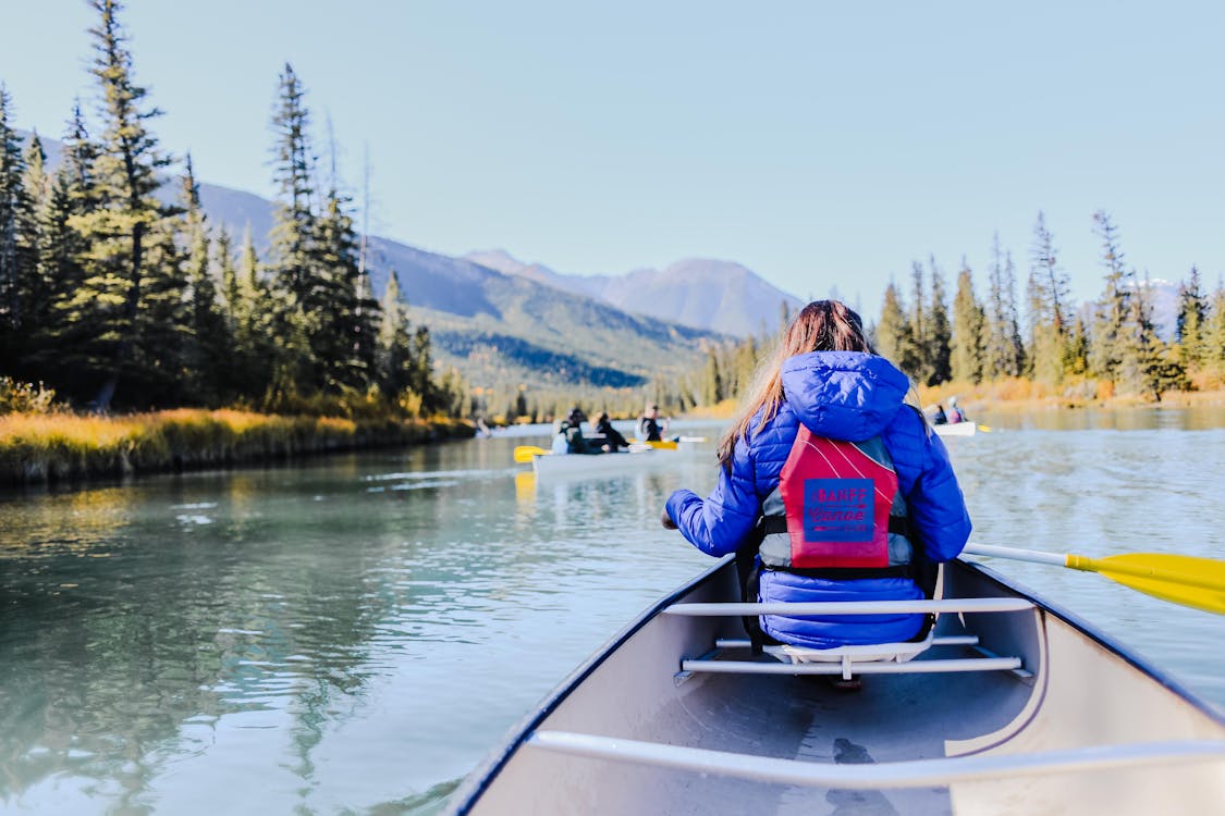 Free Back View of a Person Riding a Kayak Boat on the Lake Stock Photo