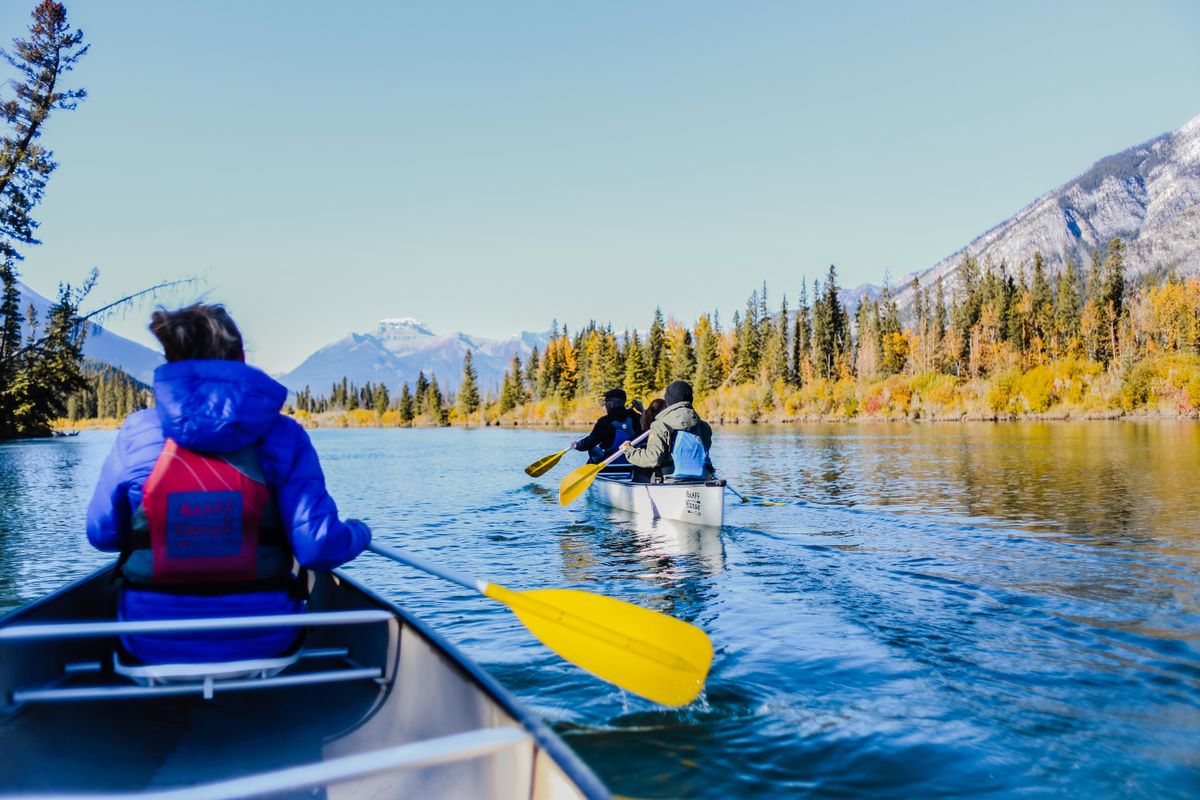 People paddling kayaks across a wide open lake