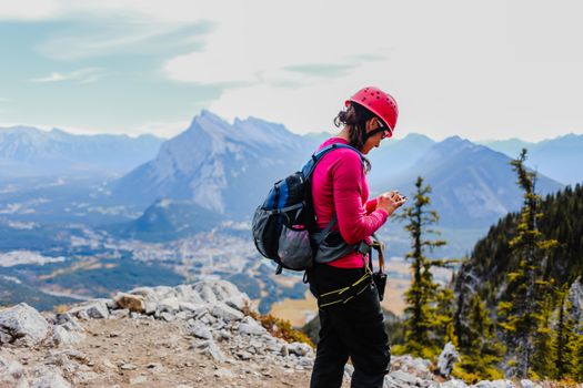 Woman in gear exploring rugged mountains with scenic views and vibrant colors.