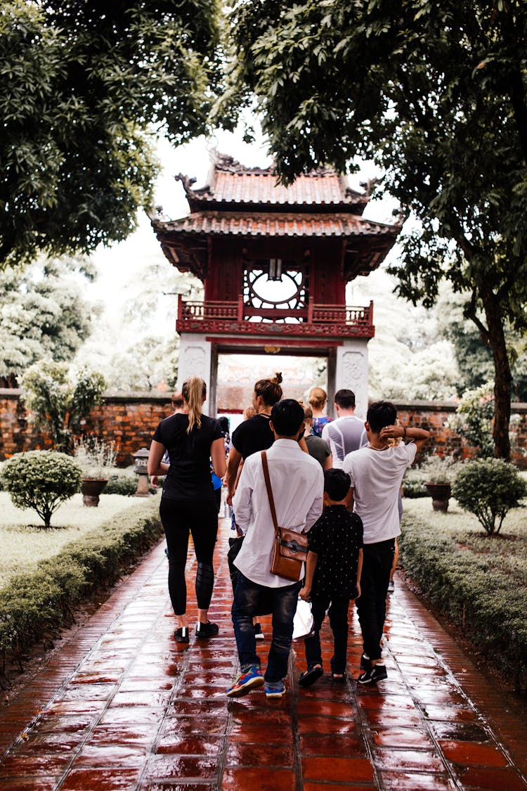 People Walking In Garden Near Traditional Asian Arch