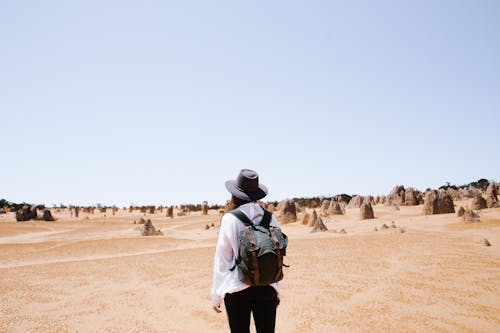 Woman Wearing a Black Hat Standing on the Desert