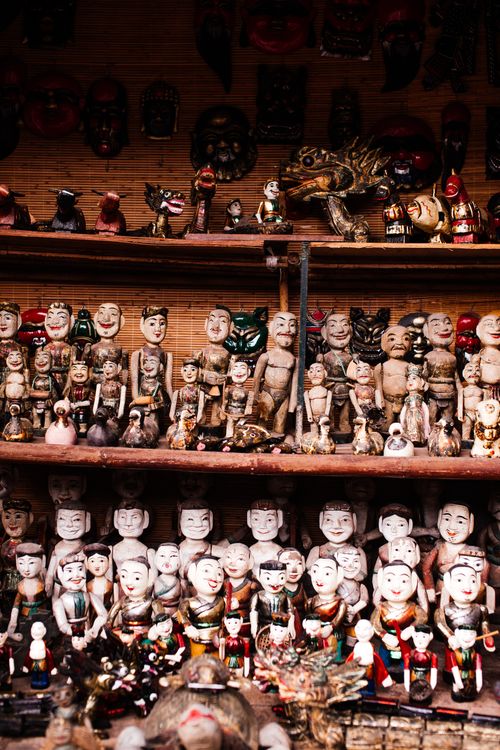 Free A collection of ethnic handmade dolls exhibited on wooden shelves in a cultural shop. Stock Photo
