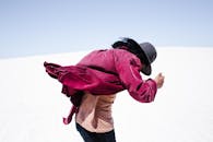 Person in Red Jacket and Blue Denim Jeans Standing on Snow Covered Ground