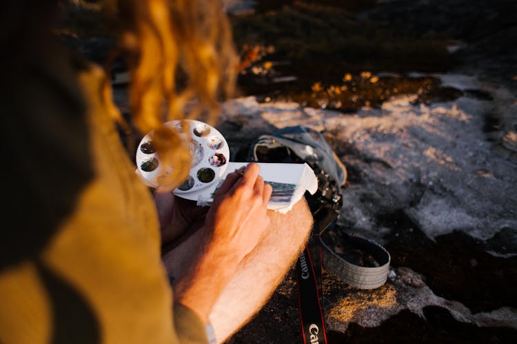 Man Painting A Tiny Watercolour In Plain-Air At Sunset