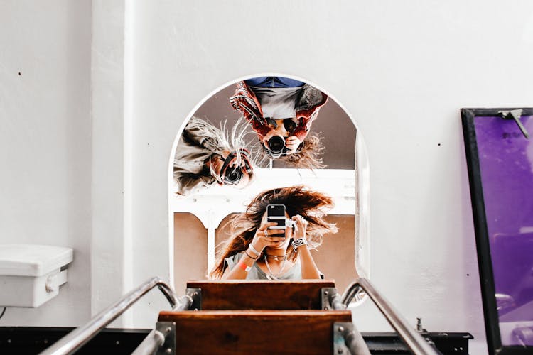 Three Women Taking A Selfie In A Mirror