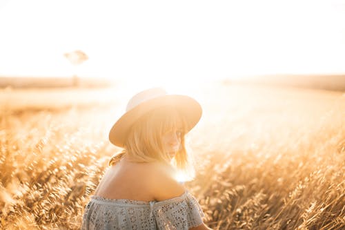 Woman in Blue Blouse Sitting on Grass Field