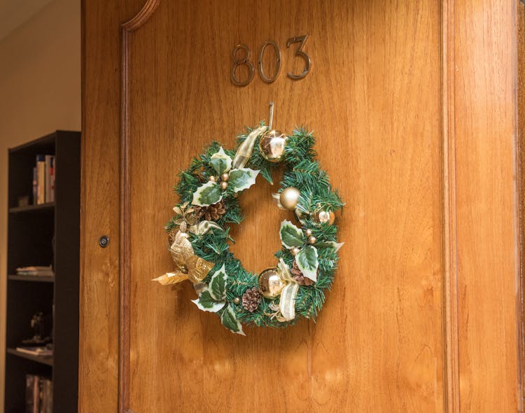 Christmas Wreath Hanging On Brown Wooden Door Of Room 803