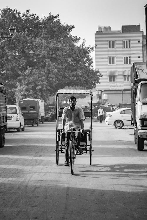 Grayscale Photo of Man Riding on a Bicycle