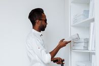 Man in White Dress Shirt Holding White Printer Paper