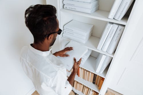 Man in White Long Sleeve Shirt Holding White Book