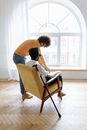 Man in Blue T-shirt Sitting on Chair