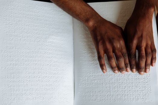 Person Holding Braille Paper on White Table