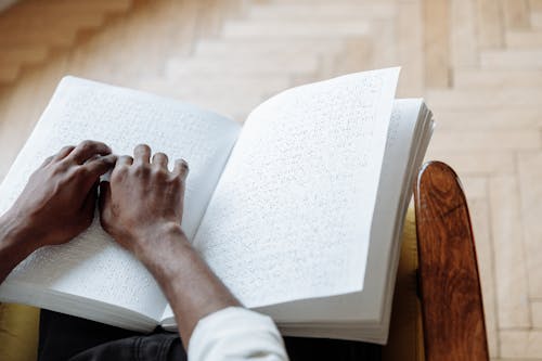 Person in White Long Sleeve Shirt Holding White Book