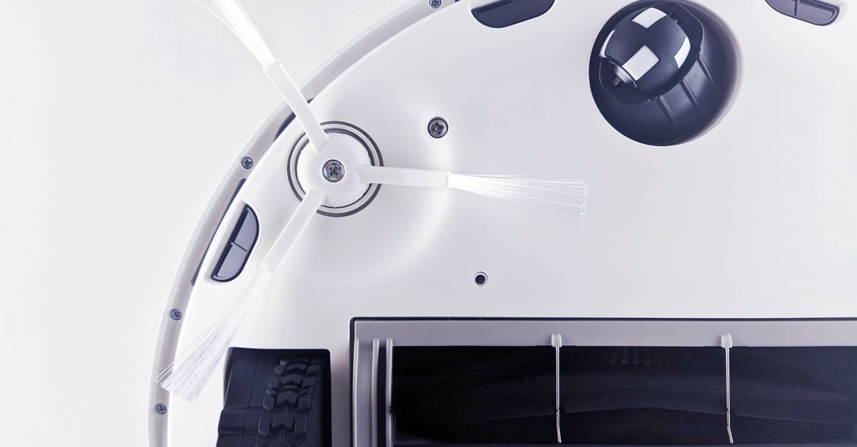 Hand die haren uit de rolborstel van een robotstofzuiger verwijdert