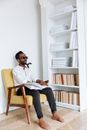 Man in White Dress Shirt and Black Pants Wearing Black Sunglasses Sitting on Brown Wooden Chair