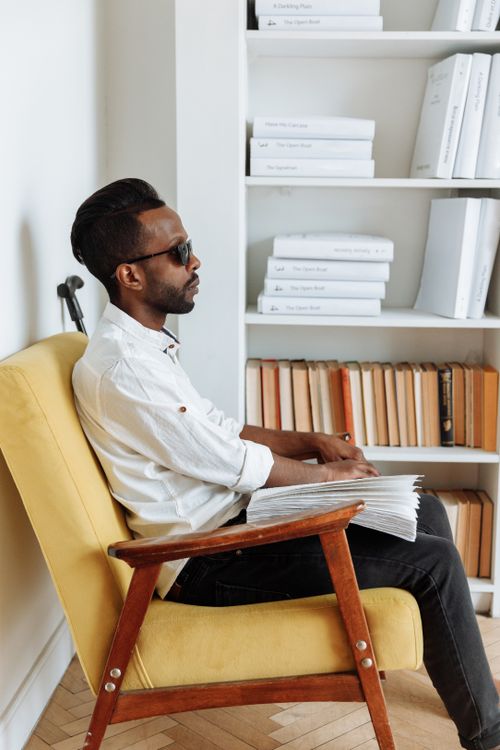 Free Profile of a visually impaired man reading a braille book indoors. Stock Photo