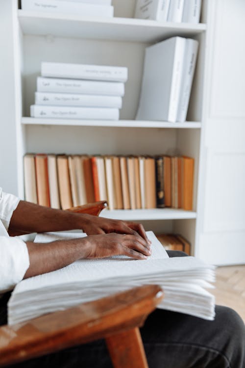 Person in White Long Sleeve Shirt Reading a Book