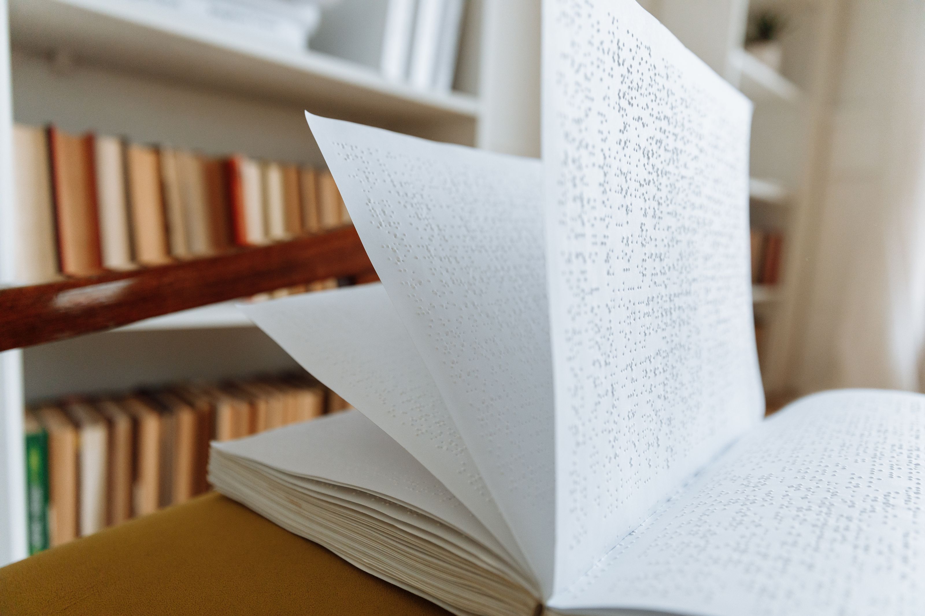 Close-up of an open braille book on a library table representing accessible reading.