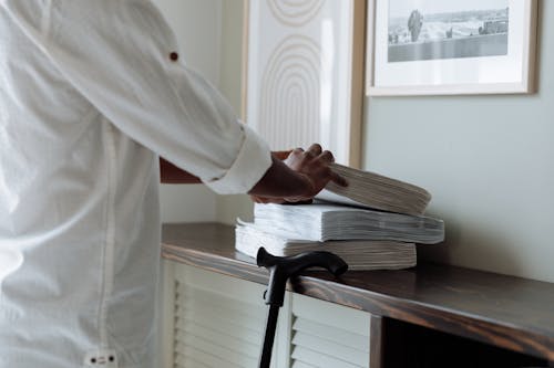 Man in White Robe Holding White Paper